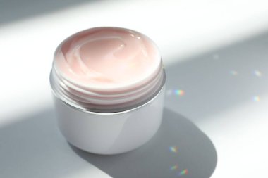 Beyaz arka planda vücut kremi kavanozu, yakın plan.