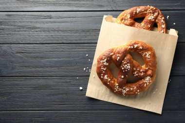 Koyu ahşap masada tuzlu krakerler, üst manzara. Metin için boşluk