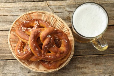 Sepette lezzetli krakerler ve ahşap masada bir bardak bira.