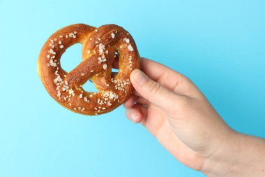 Açık mavi arka planda lezzetli krakerli kadın, yakın plan.