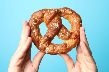 Açık mavi arka planda lezzetli krakerli kadın, yakın plan.