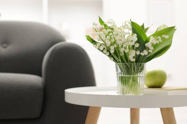 Kapalı alandaki sehpada duran bir buket güzel zambak. Metin için boşluk