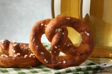 Gri arka plan karşısında lezzetli krakerler ve bir bardak bira. Yakın plan.