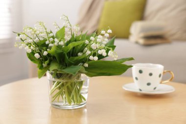 Vadideki güzel zambak buketi ve fincanı kapalı bir masada, yakın plan.
