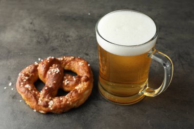 Lezzetli kraker ve bir bardak bira koyu dokulu masada, yakın plan.