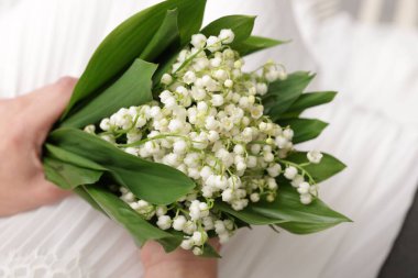 Gelin, vadideki güzel zambaklardan bir buket, kapalı bir kanepede, yakın plan.