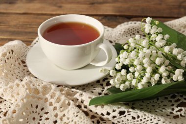 Vadi çiçeklerinin güzel zambakları ve ahşap masada çay, yakın plan.