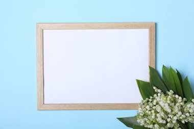 Vadideki güzel zambak çiçekleri ve açık mavi arka planda boş çerçeve, üst manzara. Metin için boşluk