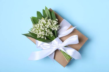 Vadideki güzel zambak çiçekleri ve açık mavi arka planda hediyeler.