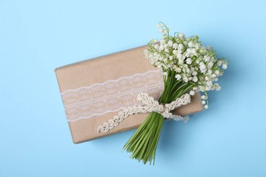 Vadideki güzel zambak çiçekleri ve açık mavi arka planda hediyeler.