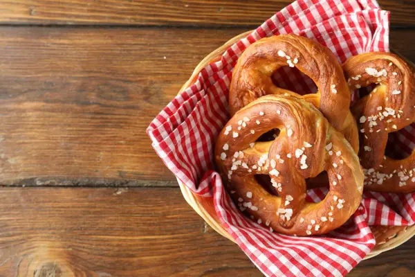 Hasır sepetin içinde tuzlu krakerler, ahşap masa, üst manzara. Metin için boşluk