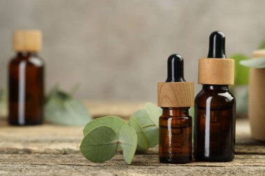 Kaliteli yağ ve okaliptüs yaprakları ahşap masada, yakın plan. Metin için boşluk