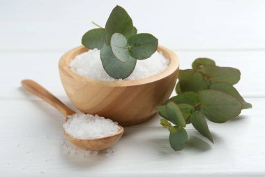 Deniz tuzu ve okaliptüs dalları beyaz ahşap masada, yakın plan.