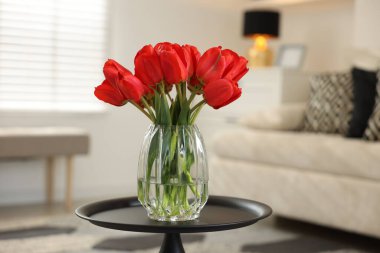 İçerideki masada vazoda güzel kırmızı laleler.