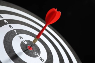 Hedef alınıyor. Siyah arkaplanda ok olan dart tahtası, yakın plan