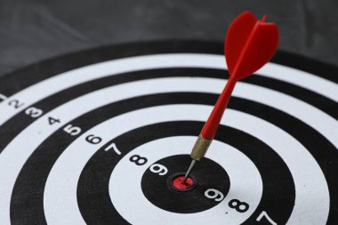 Hedef alınıyor. Gri arkaplanlı oklu dart tahtası, yakın plan