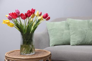 Kapalı alandaki rattan masa üzerinde güzel laleler. Metin için boşluk