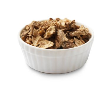 Beyaz kabın içindeki kuru hindiba kökleri.