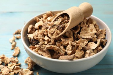 Kuru hindiba kökleri ve kaptaki kepçe mavi ahşap masa, yakın plan.