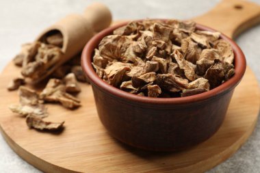 Kase içinde kurumuş hindiba kökleri ve gri masaya kepçe, yakın plan.