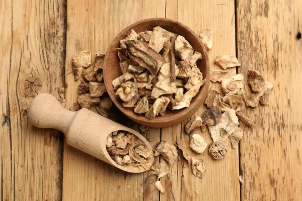 Kuru hindiba kökleri kaseye, kepçeler tahta masaya, düz yere.