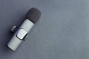 Gri arka planda Lavalier mikrofon, üst manzara. Metin için boşluk