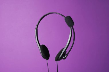 Mor arka planda mikrofonlu kulaklık.
