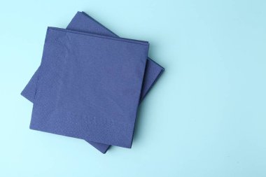 Açık mavi arka planda tek kullanımlık kağıt mendil yığını, üst manzara. Metin için boşluk