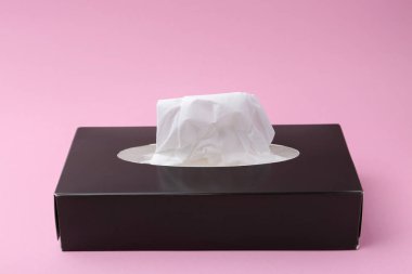 Pembe arka planda kağıt mendilli kutu, yakın plan.