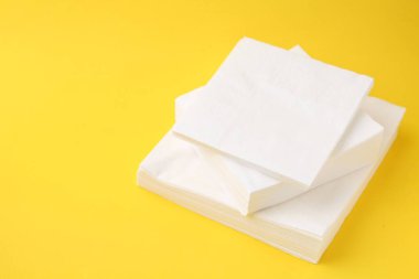 Sarı arka planda beyaz mendil yığını, yakın plan. Metin için boşluk