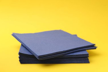 Sarı arka planda mavi mendil yığını, yakın plan. Metin için boşluk