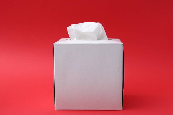 Box with paper handkerchiefs on red background