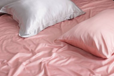 Yatakta güzel pembe ipek çarşaflar, yakın plan