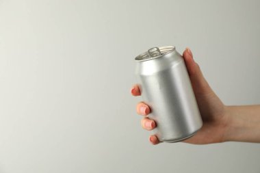 Açık gri arka planda teneke kutusu olan kadın, yakın plan. Metin için boşluk