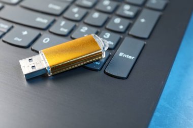 USB flash disk ve dizüstü bilgisayar mavi masada, yakın plan.