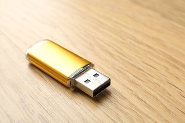 Tahta arka planda bir flaş bellek, yakın plan. Metin için boşluk