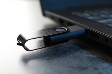 USB flaş bellek koyu gri masadaki dizüstü bilgisayara bağlandı.