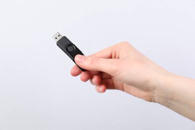 Açık gri arka planda modern flash diski olan adam, yakın plan.