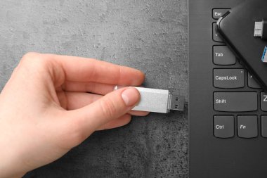 Gri masaya modern flash bellek yerleştiren adam, üst görünüm