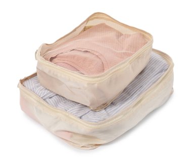 Beyaz üzerine katlanmış giysileri olan bej paketleme küpleri