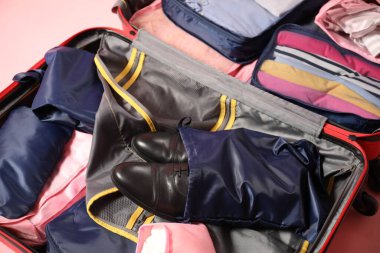 Pembe arka planda paketleme küpleri olan bavulu aç, kapat