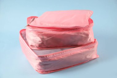 Açık mavi arkaplanda giysileri olan küpler paketleniyor, yakın plan