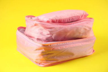 Sarı arka planda elbiseli küplerin paketlenmesi, yakın plan