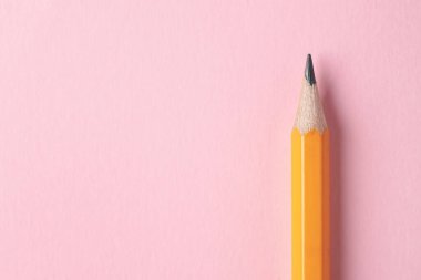 Pembe arka planda keskin bir grafit kalem, üst manzara. Metin için boşluk