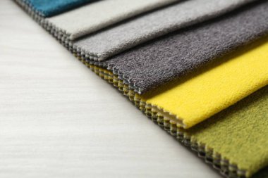 Açık ahşap masadaki farklı kumaşlardan örnekler, yakın plan. Metin için boşluk