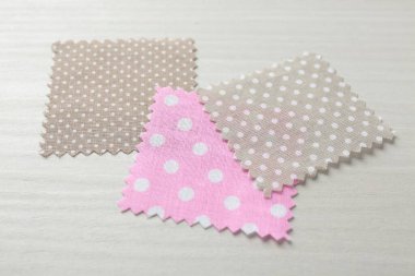 Beyaz ahşap masadaki farklı kumaşlardan örnekler, yakın plan.