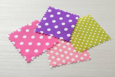 Beyaz ahşap masadaki farklı kumaşlardan örnekler, yakın plan.