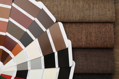 Ahşap masa üzerinde farklı kumaş ve renk seçim tablosu örnekleri, yakın plan
