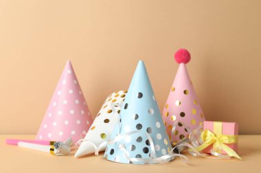 Parti şapkaları ve bej arka planda şenlik dekoru