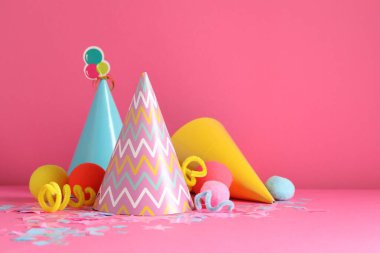 Parti şapkaları ve pembe arka planda şenlik dekoru. Metin için boşluk